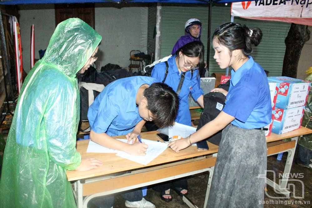 Volunteers at Luong Ngoc Quyen High School exam site help candidates drop off their belongings before entering the school.