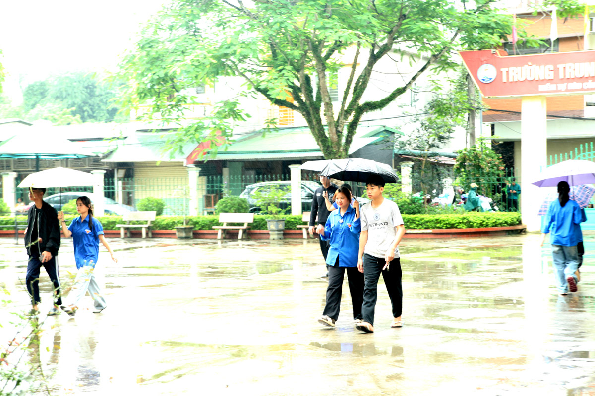 Volunteer teams assist candidates to the exam room when the weather is bad.