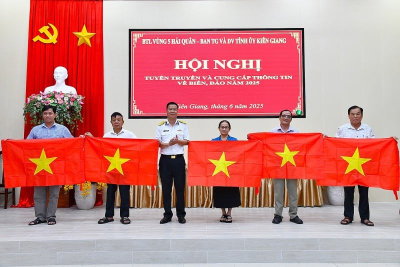 Đại tá Tăng Ngọc Thạch, Phó Chủ nhiệm Chính trị Bộ Tư lệnh Vùng 5 Hải quân tặng cờ Tổ quốc cho các đại biểu (Ảnh: Văn Định)