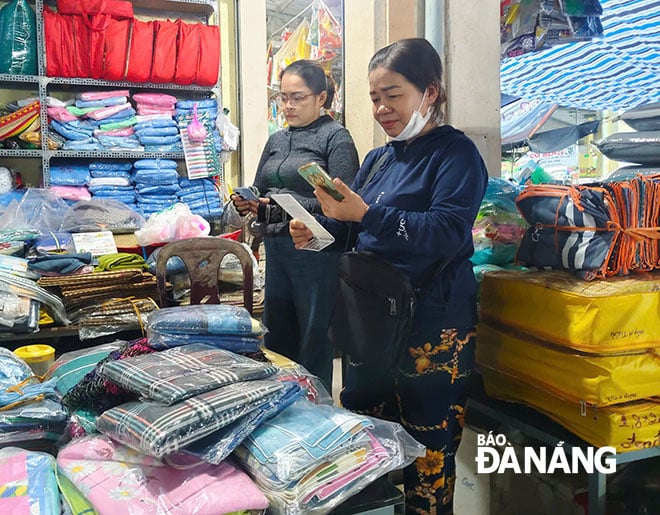 Thanh toán không tiền mặt ở chợ Lệ Trạch (xã Hòa Tiến). Ảnh: TRỌNG HUY