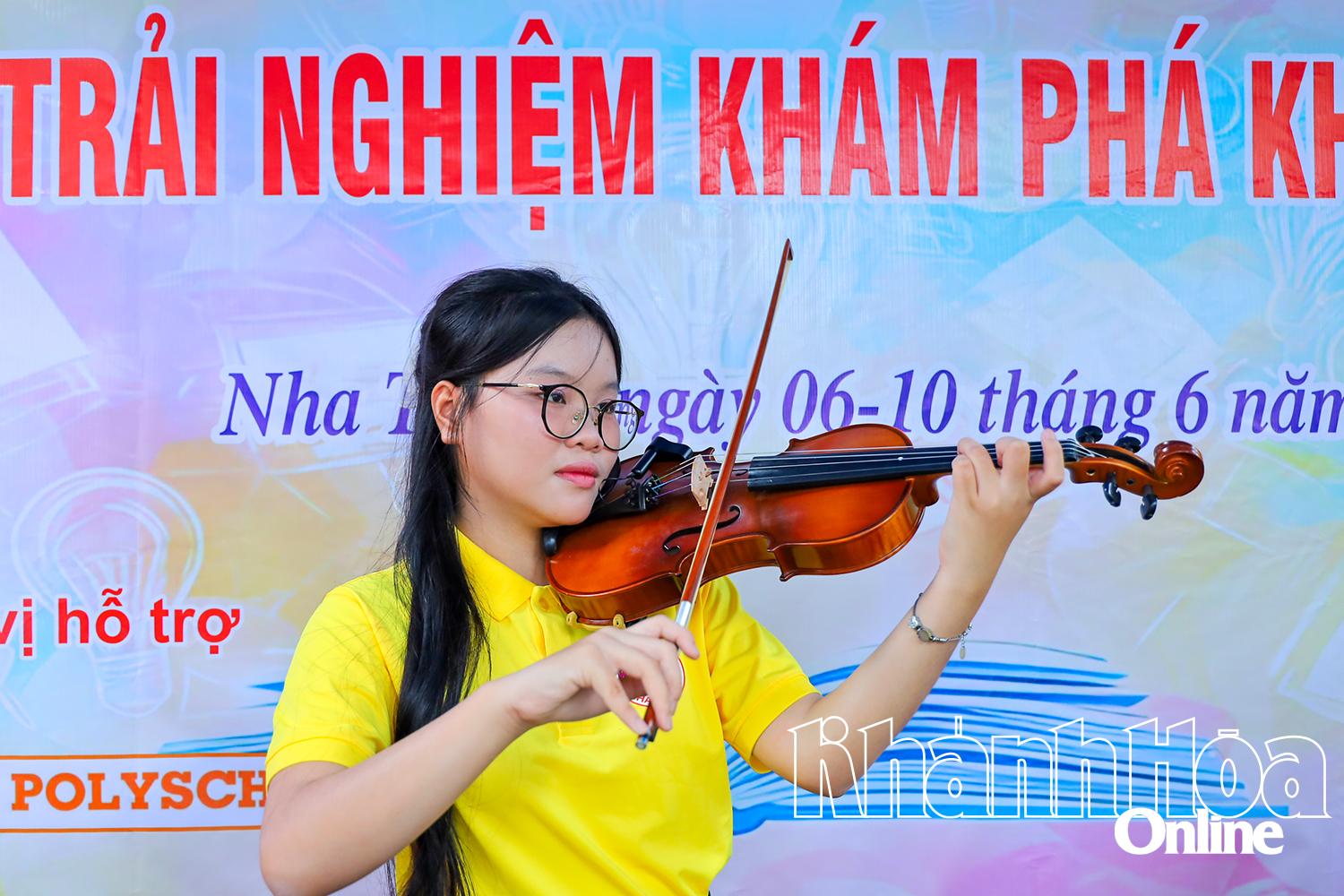 Một bạn học sinh biểu diễn đàn violin trong lễ hội sách.