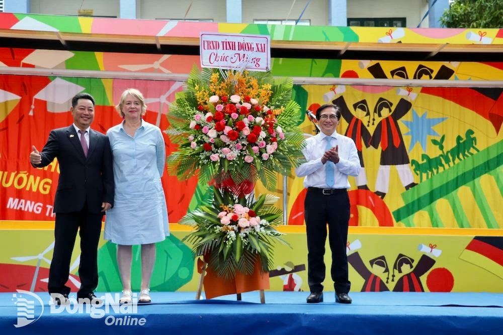 Phó chủ tịch UBND tỉnh Nguyễn Sơn Hùng tặng lẵng hoa chúc mừng Chương trình Chuyến xe hướng nghiệp Đức. Ảnh: Hải Yến