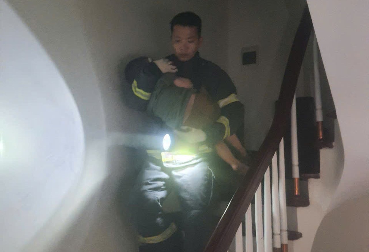 Lực lượng cứu nạn cứu hộ đưa một trẻ em trong căn nhà cháy ra ngoài an toàn.