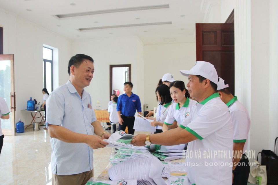 Đại diện Phòng NN&MT huyện Hữu Lũng phát áo và mũ tuyên truyền cho các đại biểu tham gia phát động (Ảnh: MAI LINH)