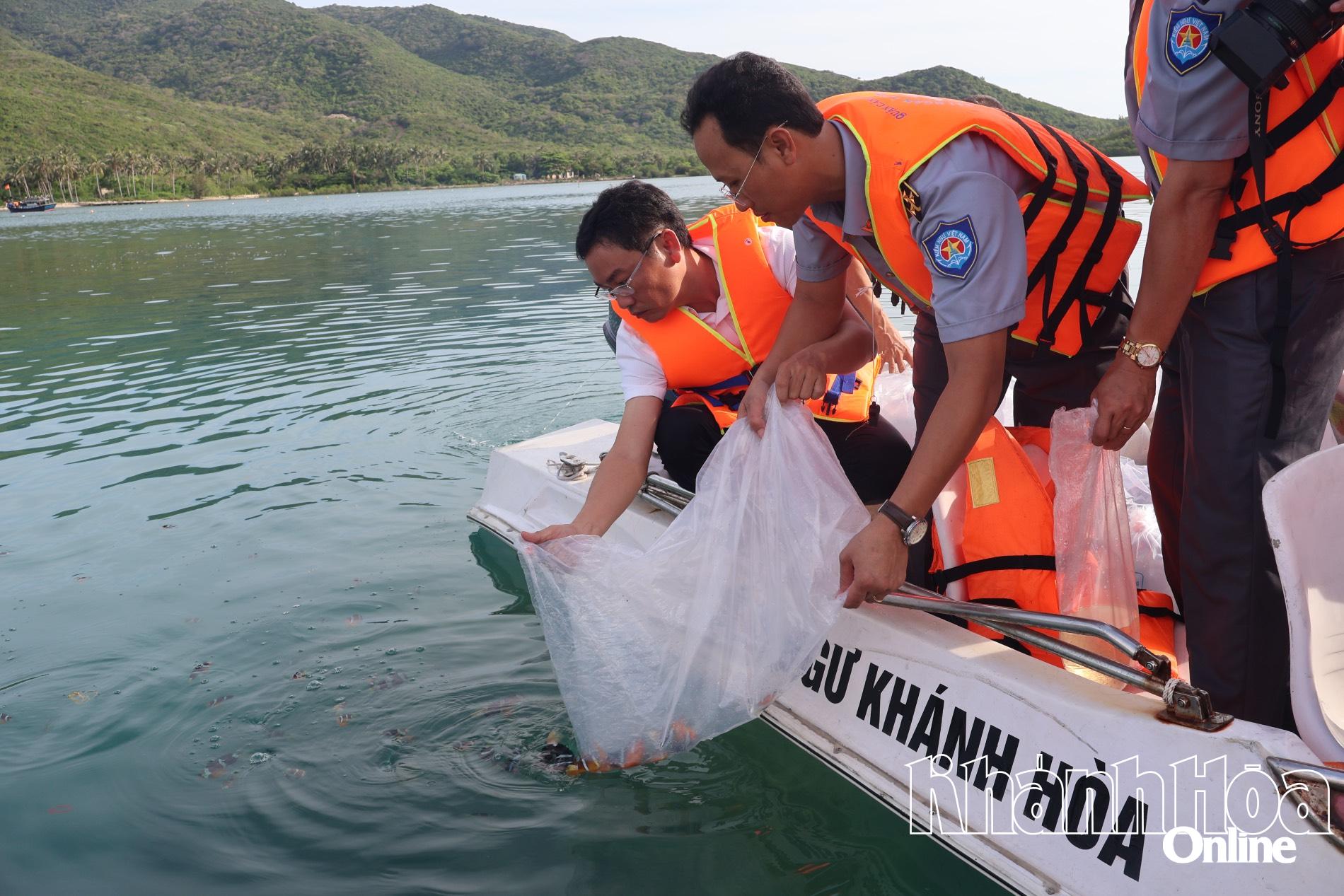 Các đại biểu thả cá giống tái tạo nguồn lợi thủy sản tại Đầm Bấy (vịnh Trang).