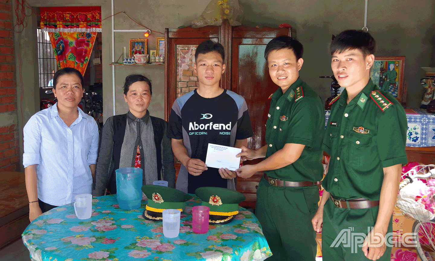  Cán bộ Đồn Biên phòng Tân Thành trao tiền hỗ trợ “Nâng bước em tới trường” cho em Nguyễn Ngọc Thái, hiện đang học tại Trường THPT Nguyễn Văn Côn (huyện Gò Công Đông). 