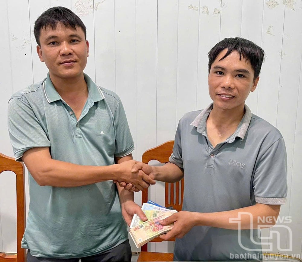 Anh Lê Đức Lợi (bên trái) trả lại số tiền hơn 20 triệu đồng cho anh Nguyễn Văn Điều.