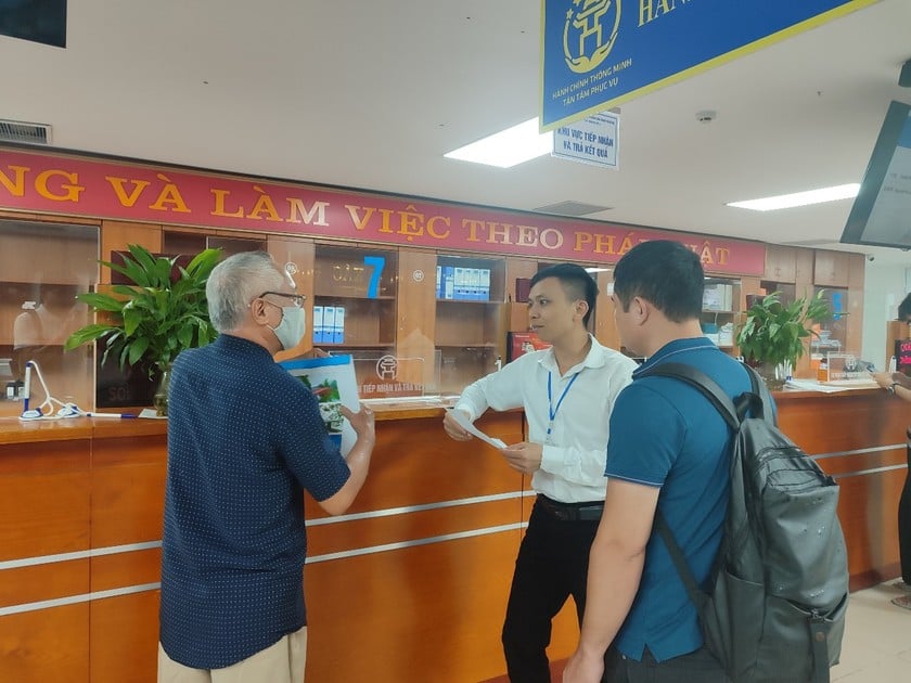 Một cán bộ UBND phường Việt Hưng hướng dẫn người dân làm TTHC.