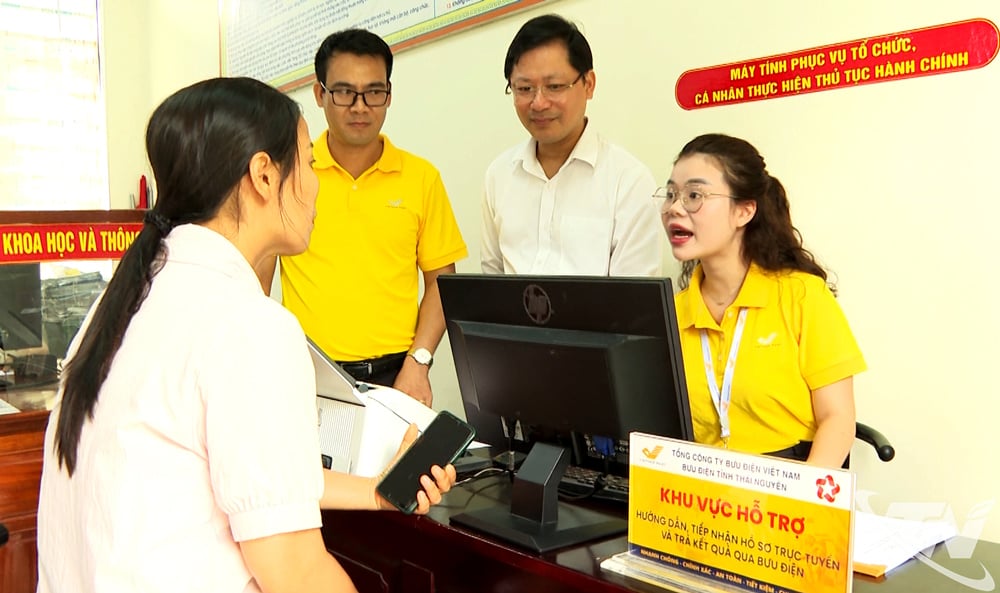 Nhân viên bưu điện hướng dẫn người dân thực hiện thủ tục hành chính tại Trung tâm Phục vụ hành chính công xã Đồng Hỷ.