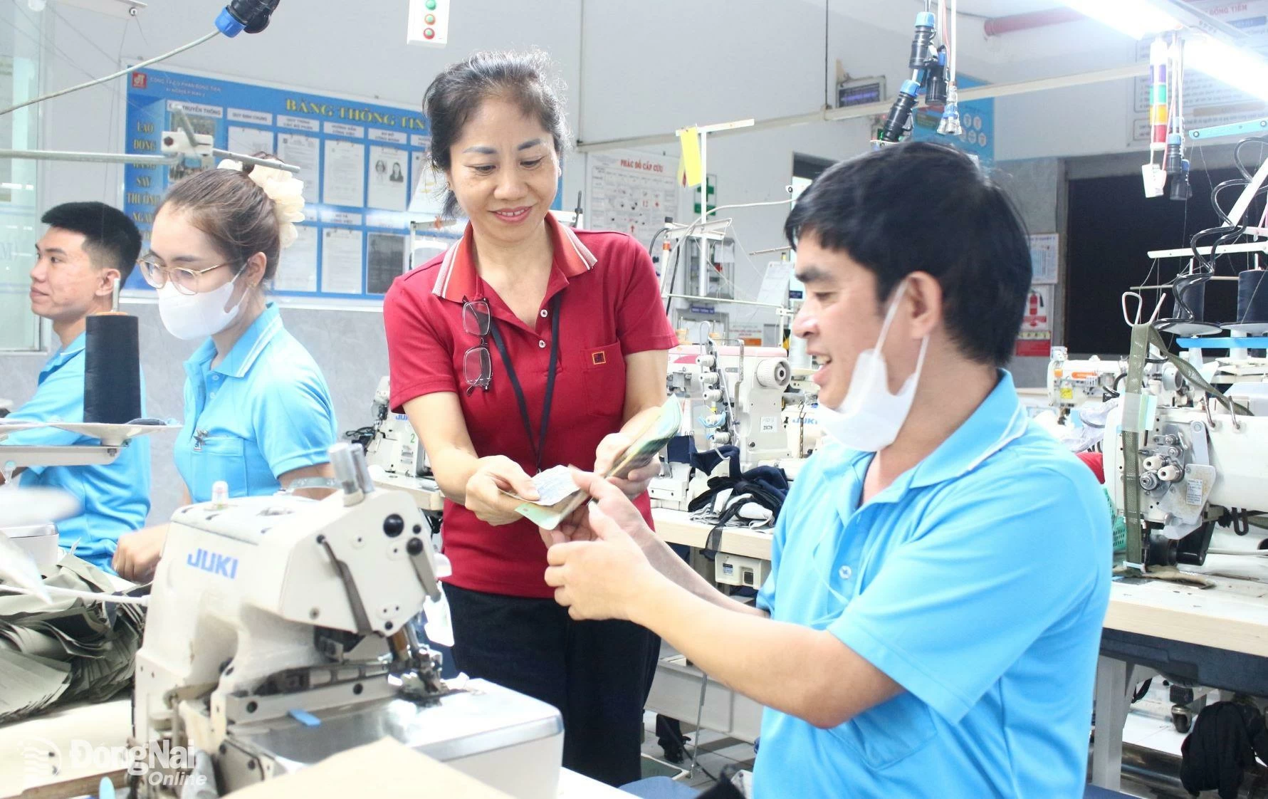 Công nhân phấn khởi nhận thưởng “nóng” tiền mặt. Ảnh: T.My