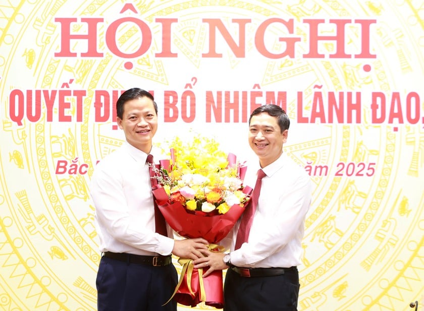 Ông Vương Quốc Tuấn tặng hoa chúc mừng ông Nguyễn Việt Oanh nhận nhiệm vụ mới.