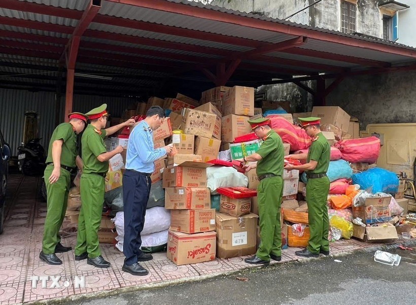 Lực lượng chức năng tiếp nhận và kiểm tra hàng hóa hết hạn sử dụng, không rõ nguồn gốc xuất xứ. (Ảnh : TTXVN phát)