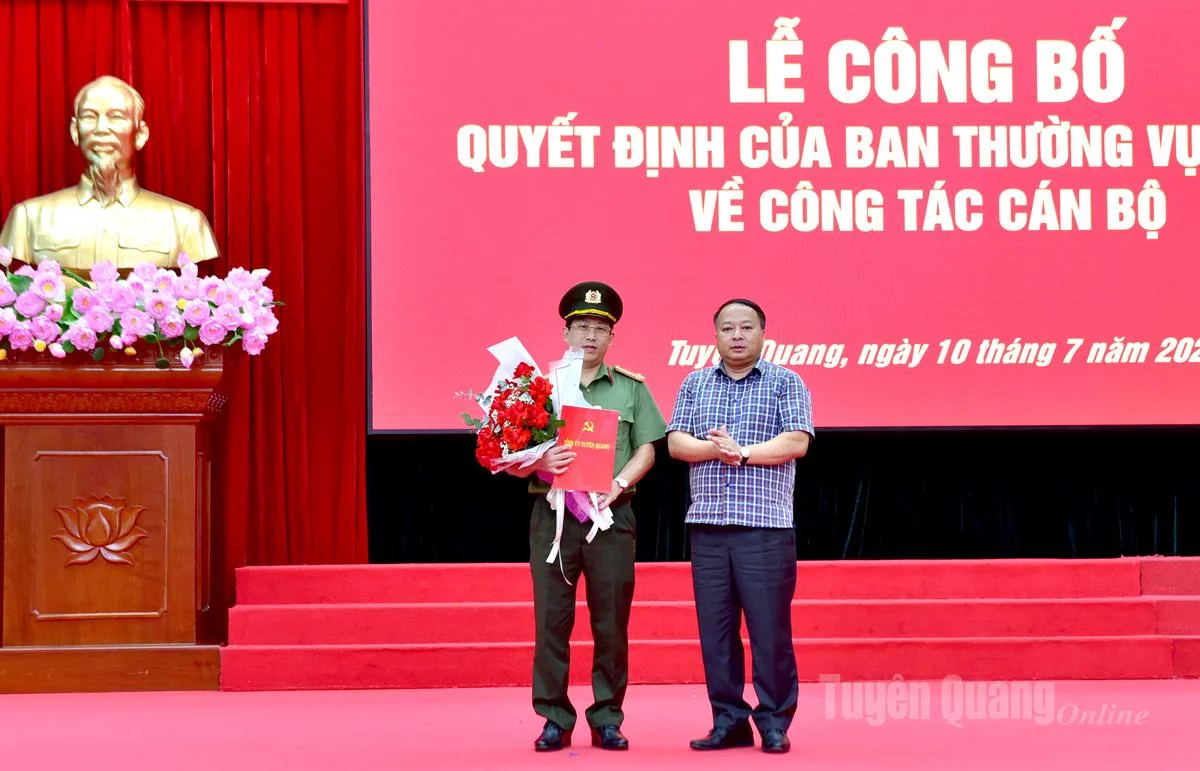 Đồng chí Chủ tịch UBND tỉnh Phan Huy Ngọc trao quyết định của Ban Thường vụ Tỉnh uỷ và tặng hoa chúc mừng Đại tá Lục Thế Hưng.