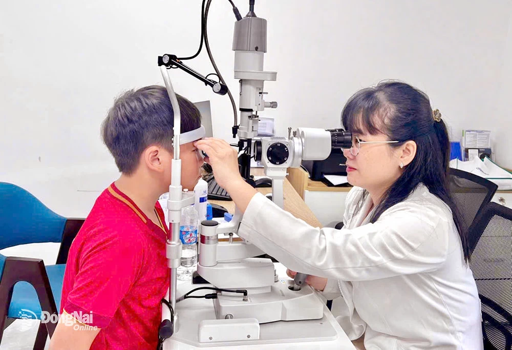Bác sĩ Vĩnh Hà khám mắt cho trẻ nhỏ tại Bệnh viện Mắt Hà Nội - Đồng Nai. Ảnh: Quang Nguyễn