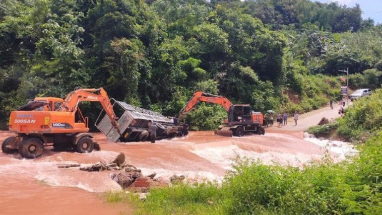 กำลังลากรถยนต์ที่เอียงเพราะน้ำท่วมไปยังที่ปลอดภัย (ภาพ: BIEN CUONG)