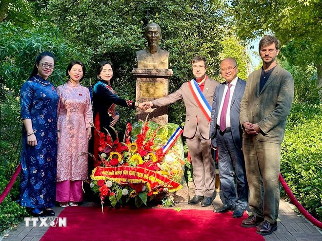 Phó Chủ tịch Quốc hội Nguyễn Thị Thanh cùng các đại biểu chụp ảnh lưu niệm trước Tượng đài Bác Hồ ở công viên Montreau. (Ảnh: Thu Hà/TTXVN)