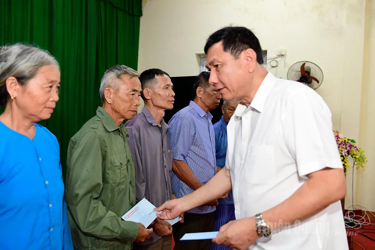 Đồng chí Phùng Tiến Quân, Trưởng Ban Nội chính Tỉnh ủy, Trưởng đoàn công tác số 7 tặng quà cho các gia đình người có công trên địa bàn xã Hồng Thái. Ảnh: Quốc Việt