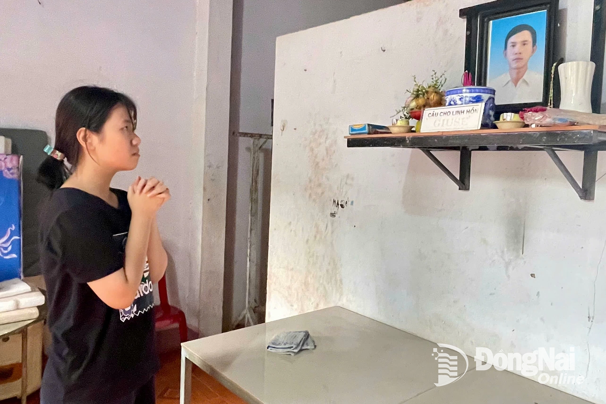 Em Lê Khả Doanh bên bàn thờ ba. Ảnh: Thu Hiền