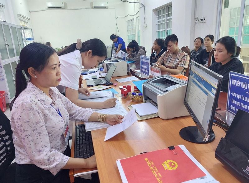 Chị Thạch Thị Bạch Nhung- công chức Trung tâm Phục vụ hành chính công xã Long Hiệp (bên trái) làm thủ tục cho người dân.