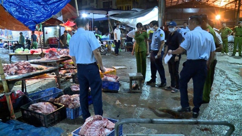 Lực lượng chức năng kiểm tra ki-ốt kinh doanh thịt lợn "bẩn" tại khu vực chợ Phùng Khoang. (Ảnh: Công an thành phố Hà Nội cung cấp)