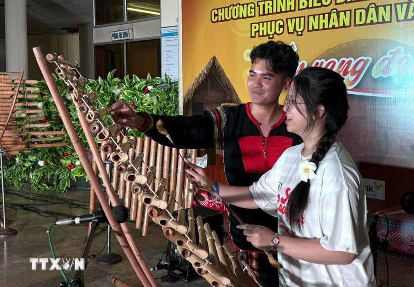Sinh viên Việt Nam ở nước ngoài trải nghiệm nhạc cụ đàn T'rưng. (Ảnh: Tường Quân/TTXVN)