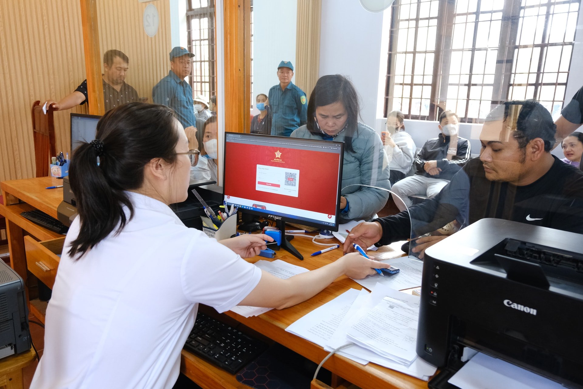 Cán bộ xã hỗ trợ người dân đăng ký VNeID và nộp hồ sơ trực tuyến