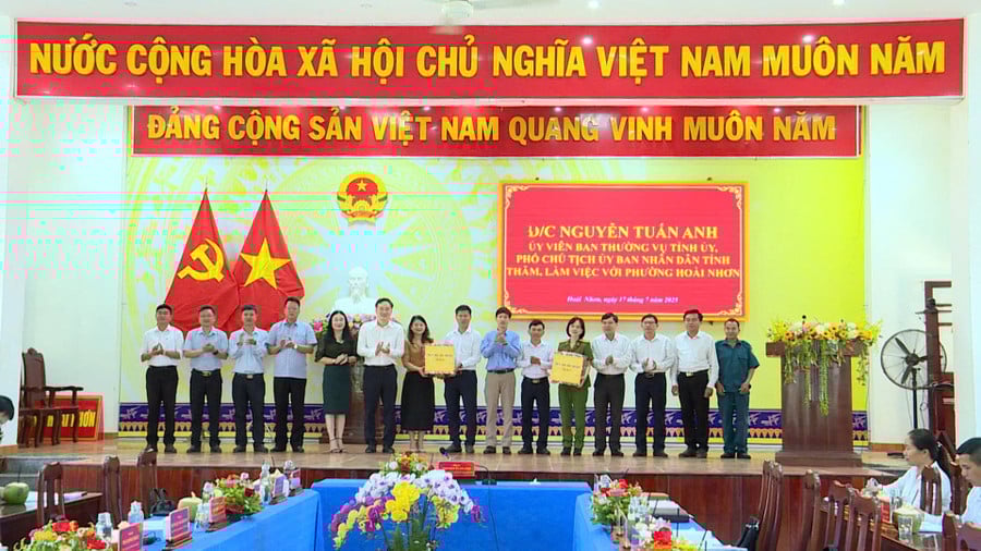 Phó Chủ tịch UBND tỉnh Nguyễn Tuấn Anh (thứ 6 từ trái sang) tặng quà cho lãnh đạo phường Hoài Nhơn. Ảnh: Phi Long