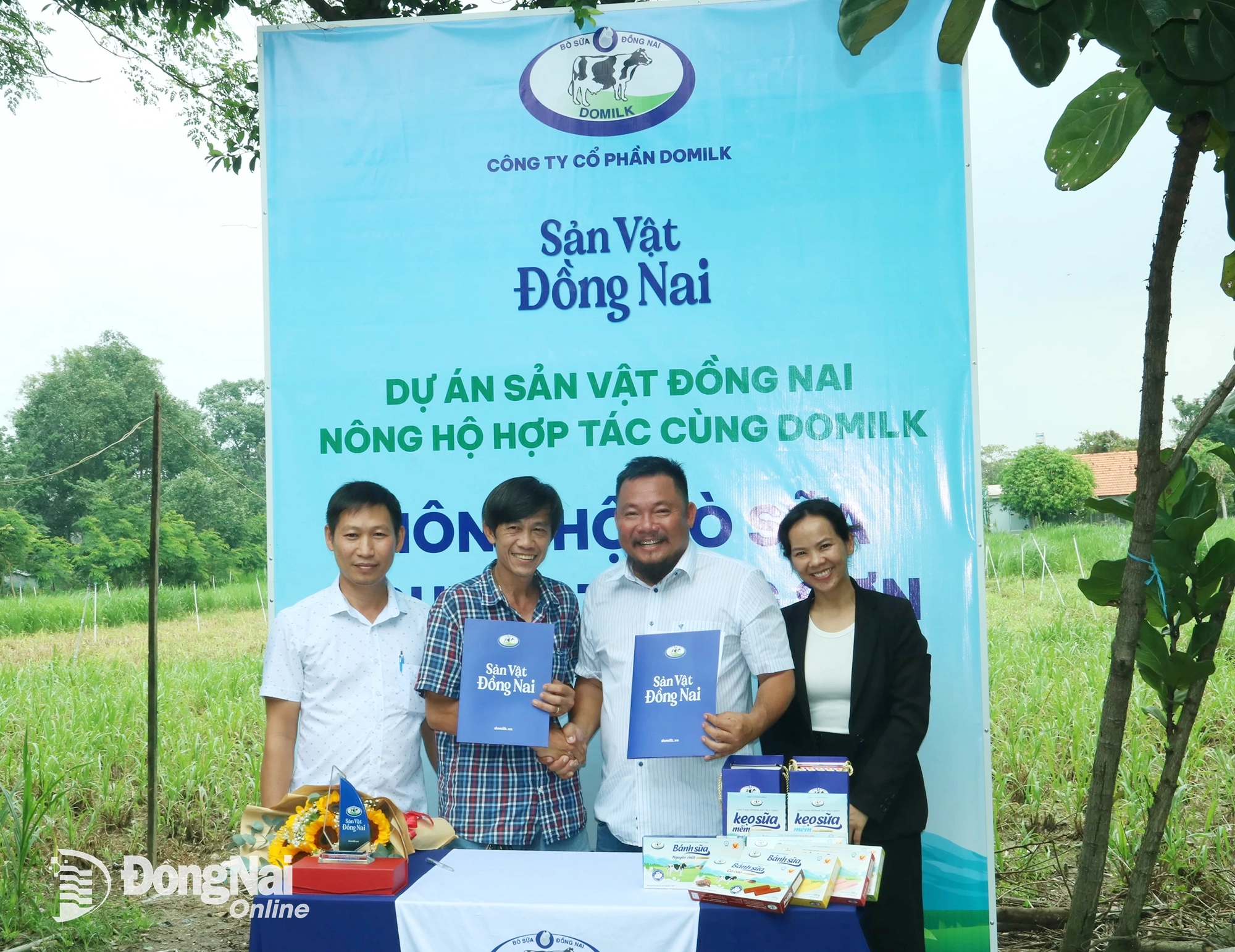 Đại diện Công ty Cổ phần Domilk (bên phải) trao bản ký kết hợp tác với nông hộ Nguyễn Trung Sơn (xã Long Thành). Ảnh: Vương Thế