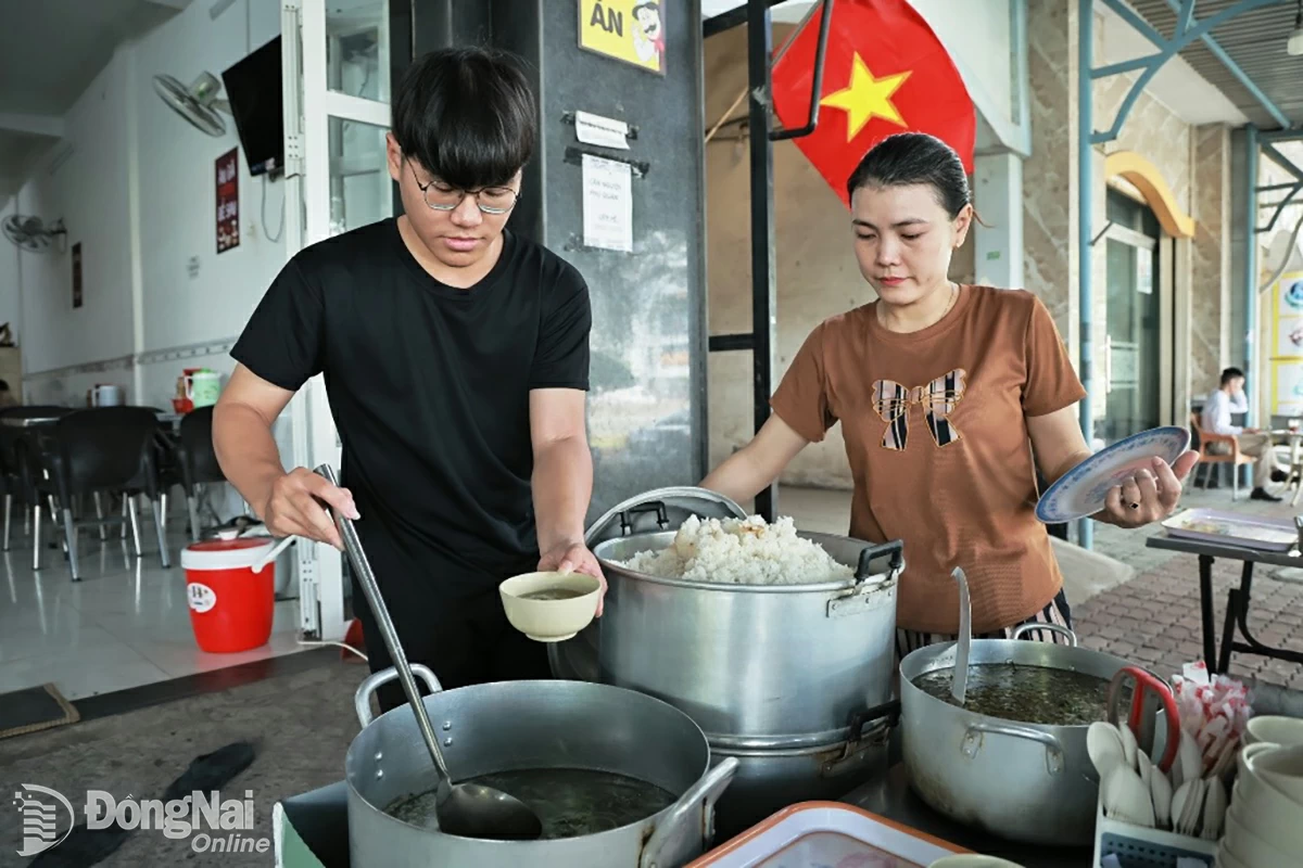Doan Nguyen Thang helps his mother sell rice in Bien Hoa ward.