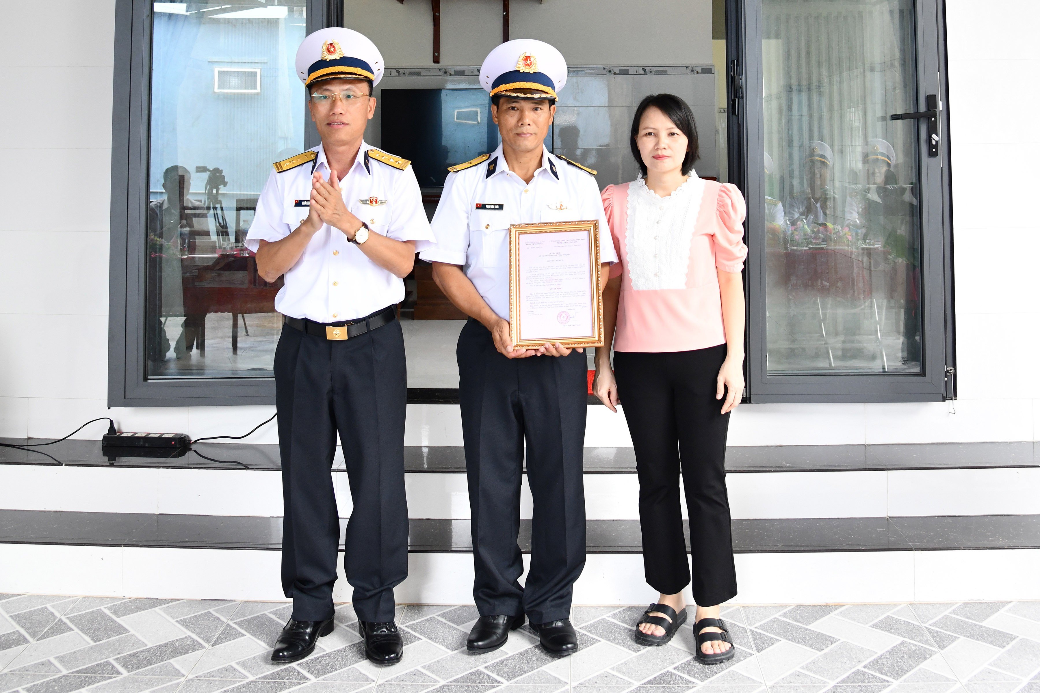 Chính ủy Vùng 5 Hải quân trao quyết định bàn giao nhà đồng đội cho gia đình Thiếu tá Quân nhân chuyên nghiệp Phạm Văn Thức. (Ảnh: Kiên Định)