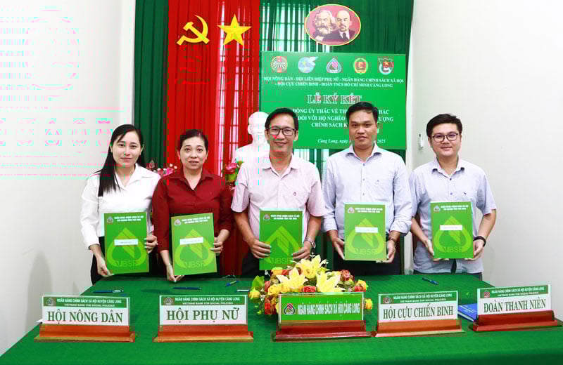 Ông Trần Quốc Phong- Giám đốc Phòng giao dịch NHCSXH Càng Long  (giữa) cùng lãnh đạo các tổ chức chính trị - xã hội xã Càng Long ký kết hợp đồng ủy thác.