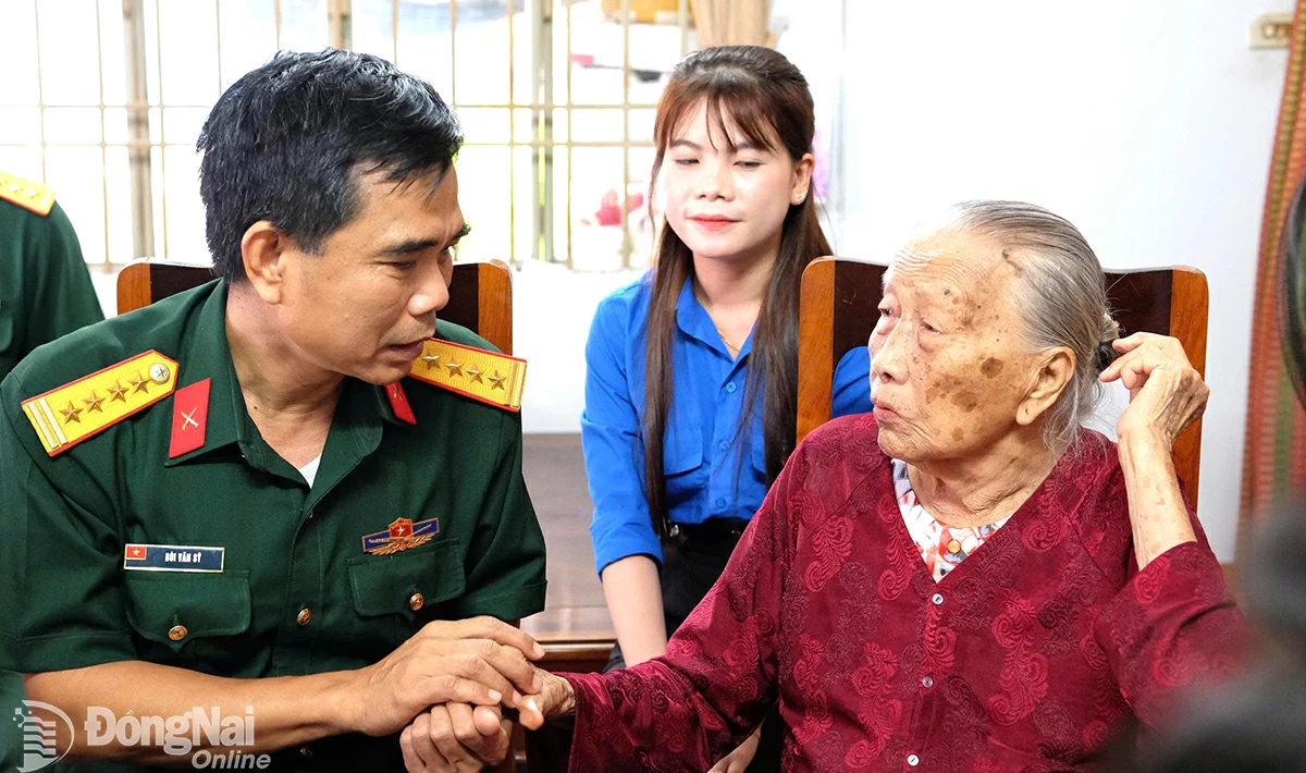 Đại tá Bùi Văn Sỹ, Phó chính ủy Bộ Chỉ huy quân sự tỉnh thăm, tặng quà Mẹ Việt Nam anh hùng Đỗ Thị Miên. Ảnh: Gia Tú - Xuân Lượng
