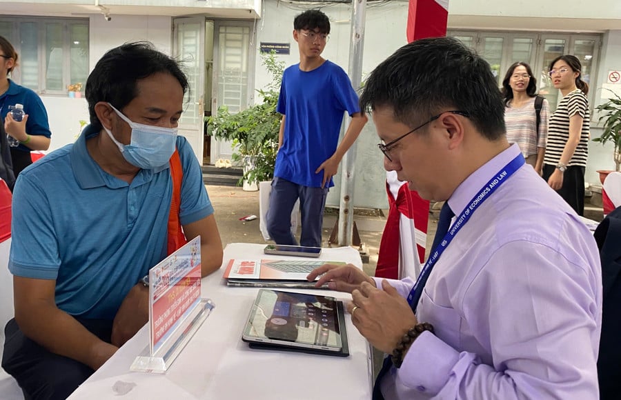 Theo ThS Cù Xuân Tiến, Trưởng phòng Tuyển sinh và Công tác sinh viên Trường Đại học Kinh tế - Luật (Đại học Quốc gia TPHCM) tư vấn cho phụ huynh. Ảnh: Lê Nam