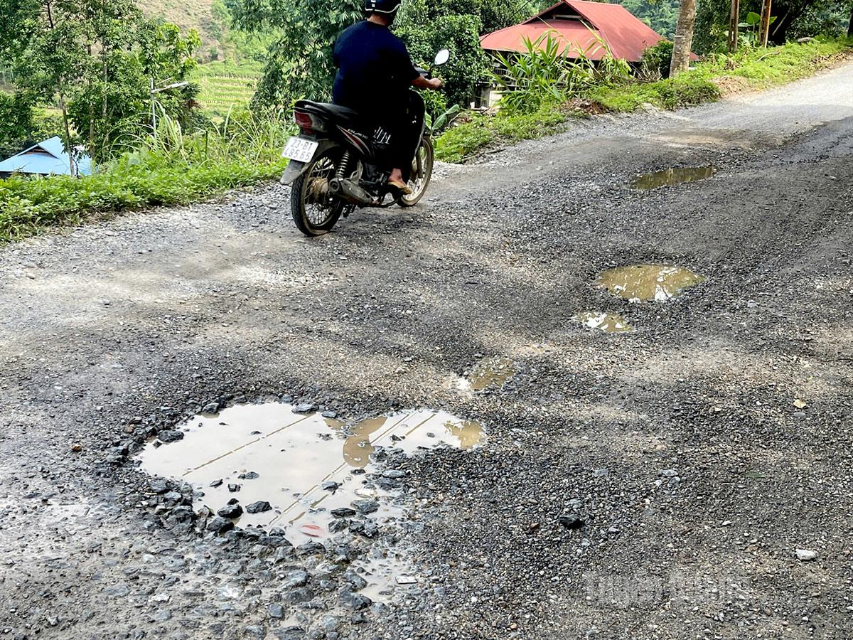Mặt đường xuất hiện nhiều ổ gà lởm chởm, gây nguy hiểm cho người đi đường.