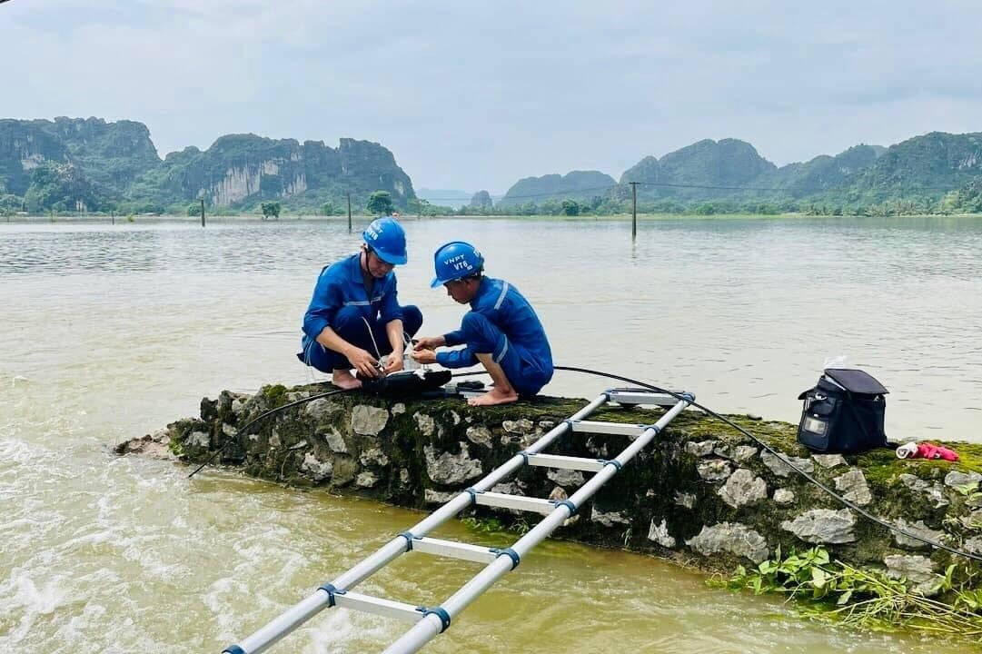 Không quản ngập lụt, đội ngũ kỹ thuật VNPT Hà Nội vẫn đang khẩn trương khắc phục sự cố để cung cấp dịch vụ cho khách hàng. Ảnh: VNPT Hà Nội