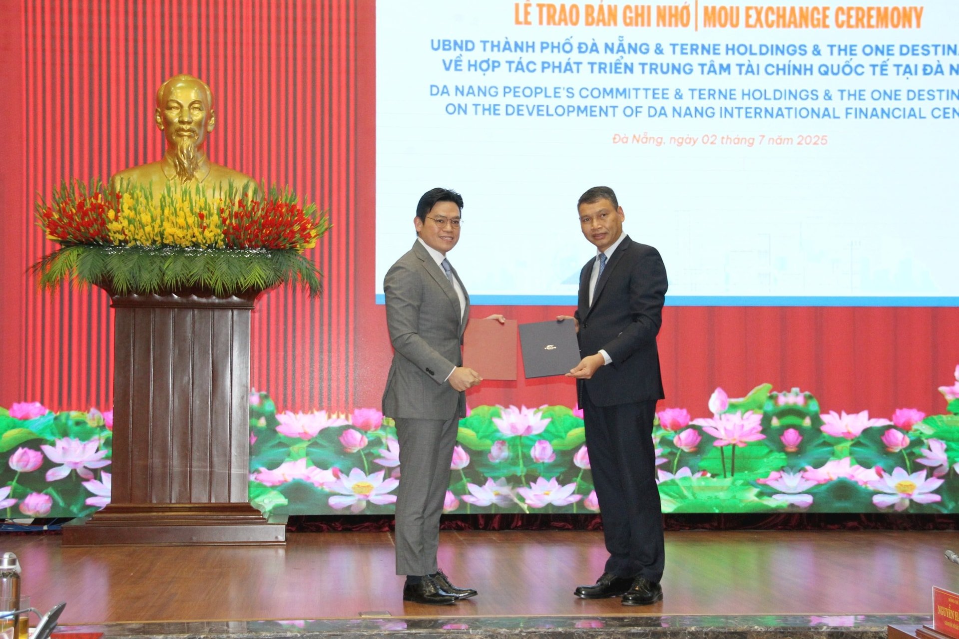 Phó Chủ tịch UBND thành phố Hồ Kỳ Minh (bên phải) trao bản ghi nhớ (MOU) hợp tác phát triển Trung tâm tài chính quốc tế Đà Nẵng cho nhà đầu tư. Ảnh: TRỌNG HÙNG