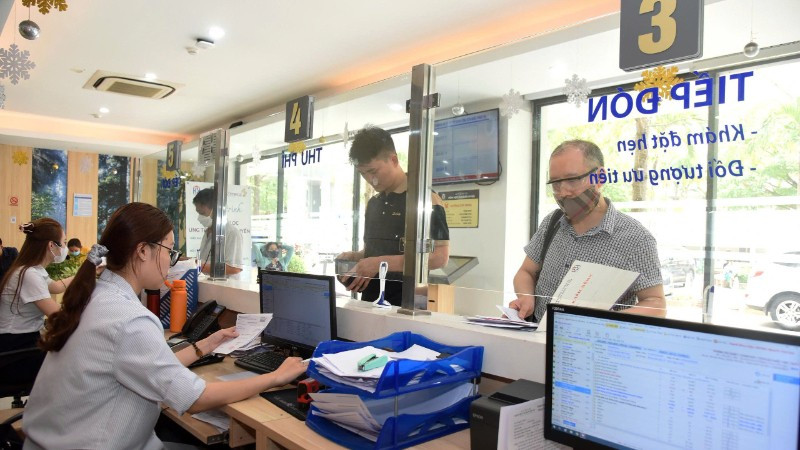 Staff at Hanoi Oncology Hospital guide patients through health insurance examination and treatment procedures. (Photo: KHÁNH AN)