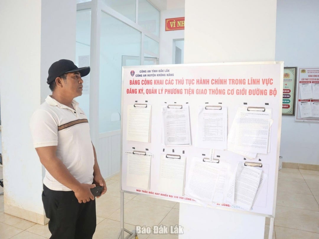 People view the public posting of vehicle registration procedures at the headquarters of the Krong Nang Commune Police.