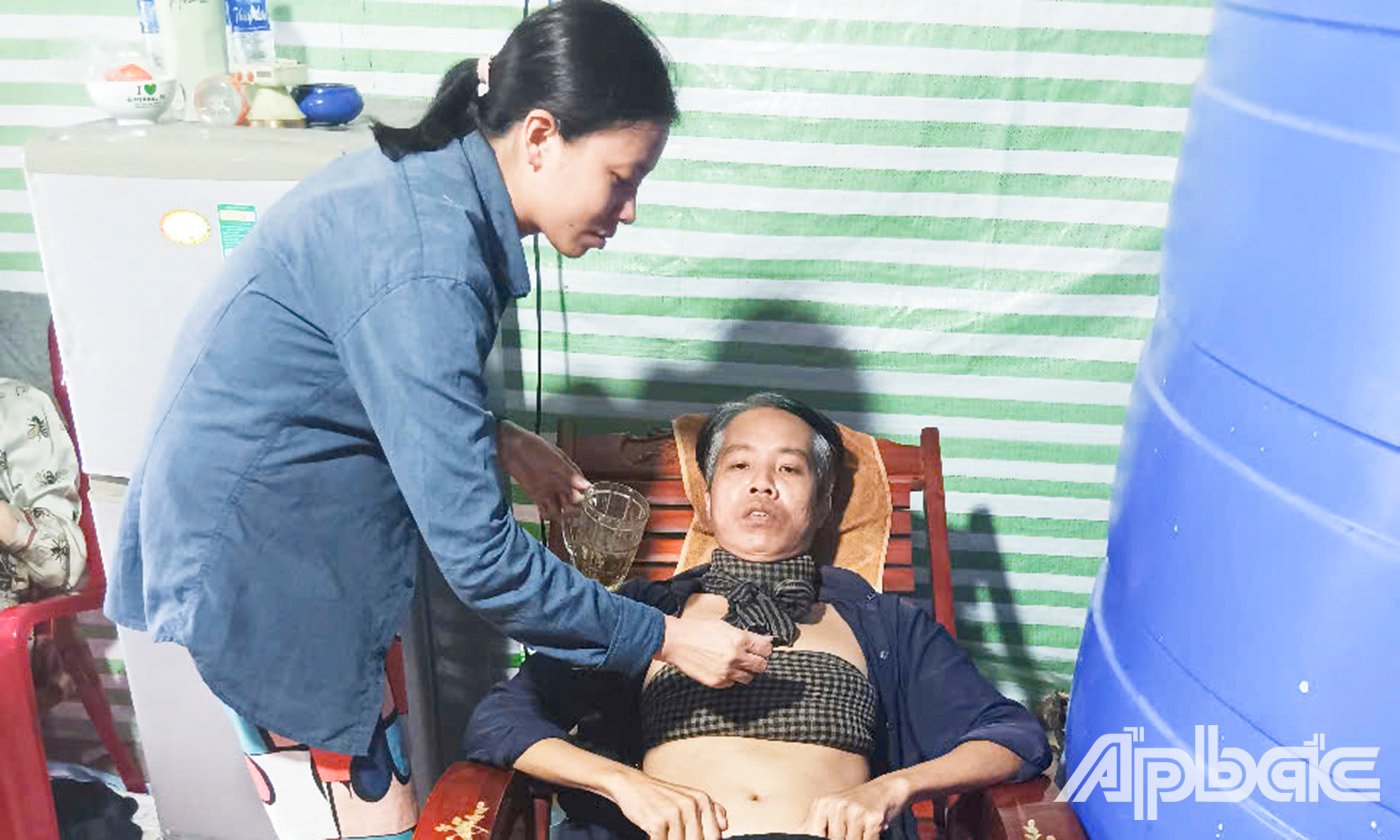 Chị Trần Thị Ấm đang chăm sóc anh Lê Quốc Chỉnh – người chồng đang bệnh nặng.