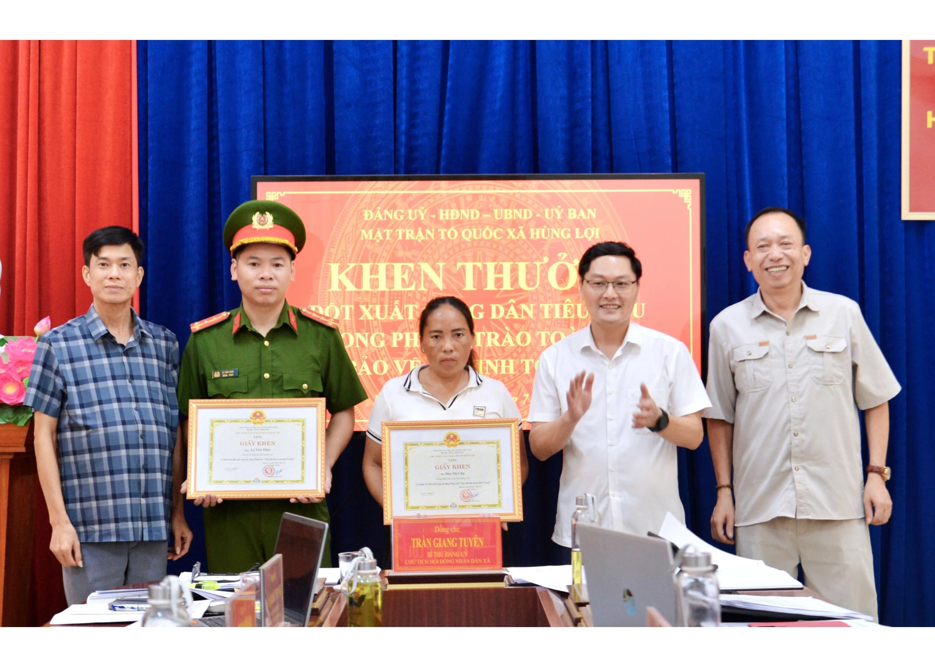 Lãnh đạo xã Hùng Lợi trao Giấy khen cho hai cá nhân.