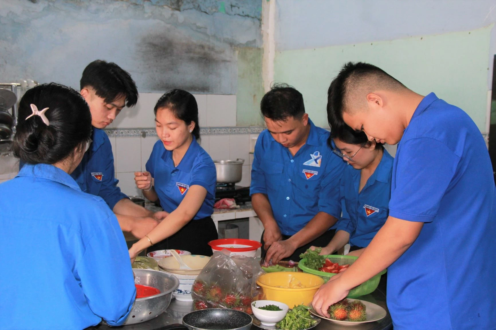 Funcionarios, sindicalistas y jóvenes del barrio de Tam Phuoc preparan y disfrutan de una comida con cariño en casa de la familia de un mártir. Foto: Nga Son
