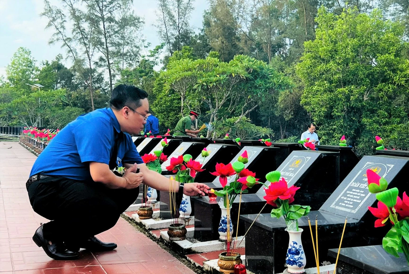 El Sr. Nguyen Minh Kien, miembro del Comité Ejecutivo Central de la Unión de Jóvenes, miembro del Comité Provincial del Partido, vicepresidente del Comité Provincial del Frente de la Patria y secretario de la Unión Provincial de Jóvenes, encendió velas para rendir homenaje a las tumbas de los mártires. Foto: DVCC