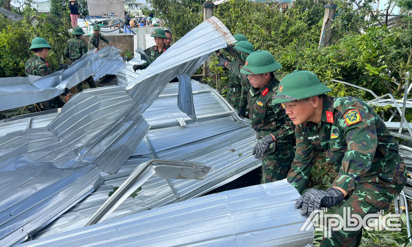 Cán bộ, chiến sĩ Tiểu đoàn 502, Trung đoàn 320, Bộ Chỉ huy Quân sự tỉnh Đồng Tháp giúp nhân dân khắc phục hậu quả thiên tai.