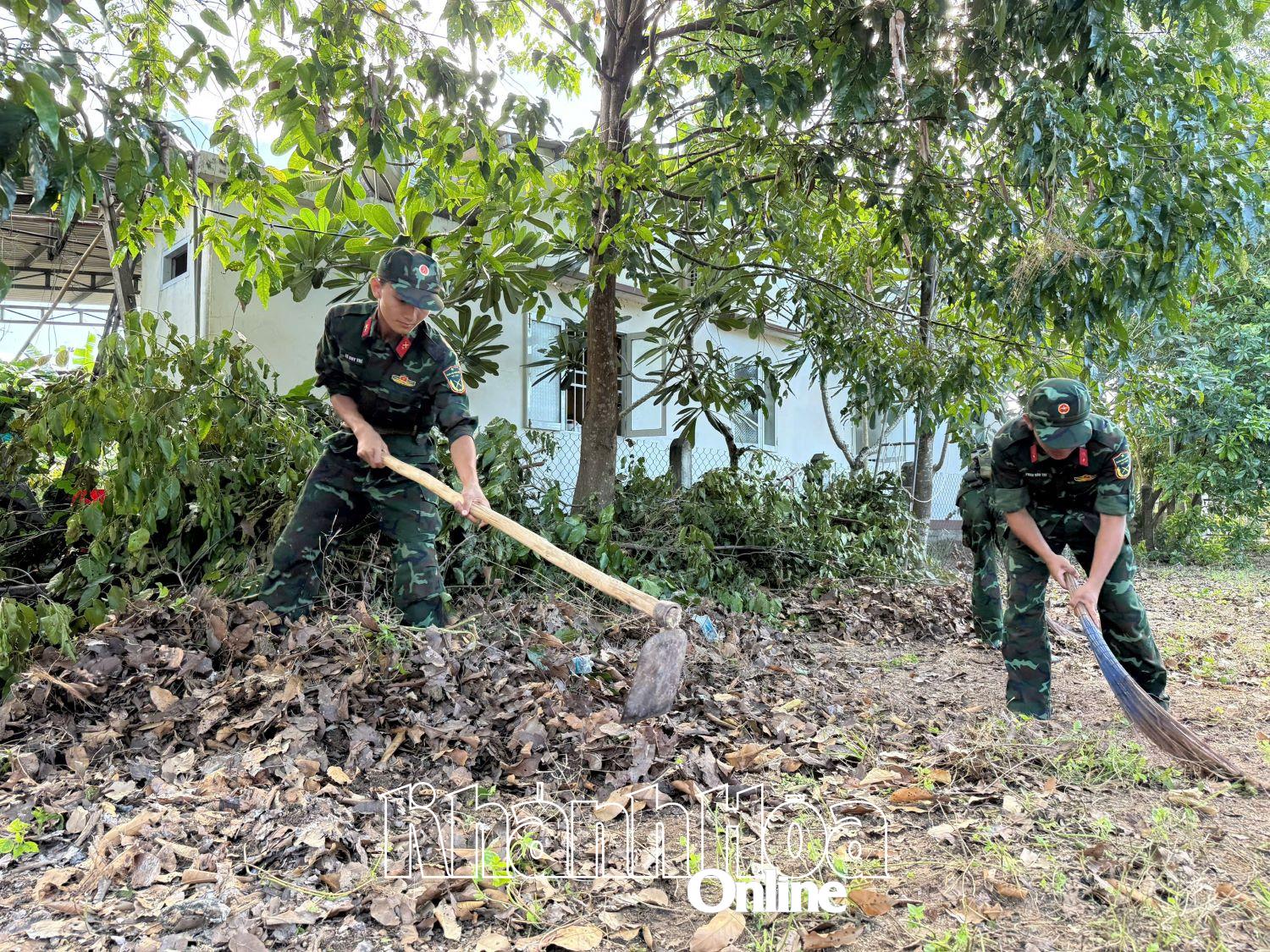 Cán bộ, chiến sĩ dọn vệ sinh dọc các tuyến đường liên thôn.