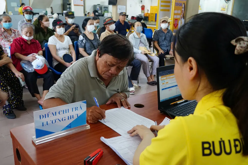 Nhân viên bưu điện TPHCM chi trả lương hưu cho người hưởng.jpg