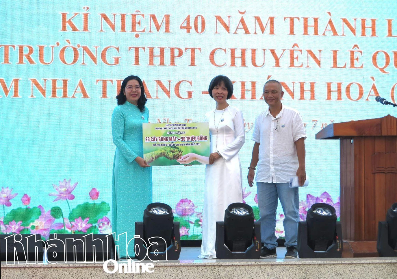 Đại diện cựu học sinh trao bảng tượng trưng học bổng và cây xanh tặng cho nhà trường. 