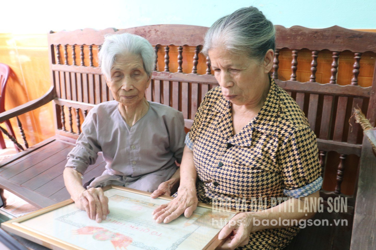 Mẹ Nguyễn Thị Gái (bên trái), khu 3, xã Thất Khê ngắm nhìn lại tấm bằng  Tổ quốc ghi công liệt sỹ Nguyễn Anh Tuấn 