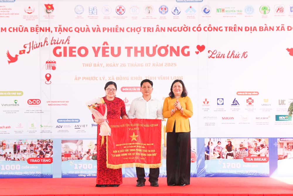 Đồng chí Hồ Thị Hoàng yến- Phó Bí thư Thường trực Tỉnh ủy tặng cờ thi đua của Chính phủ cho tập thể Nhân dân và cán bộ xã Định Thủy, huyện Mỏ Cày Nam,  tỉnh Vĩnh Long.