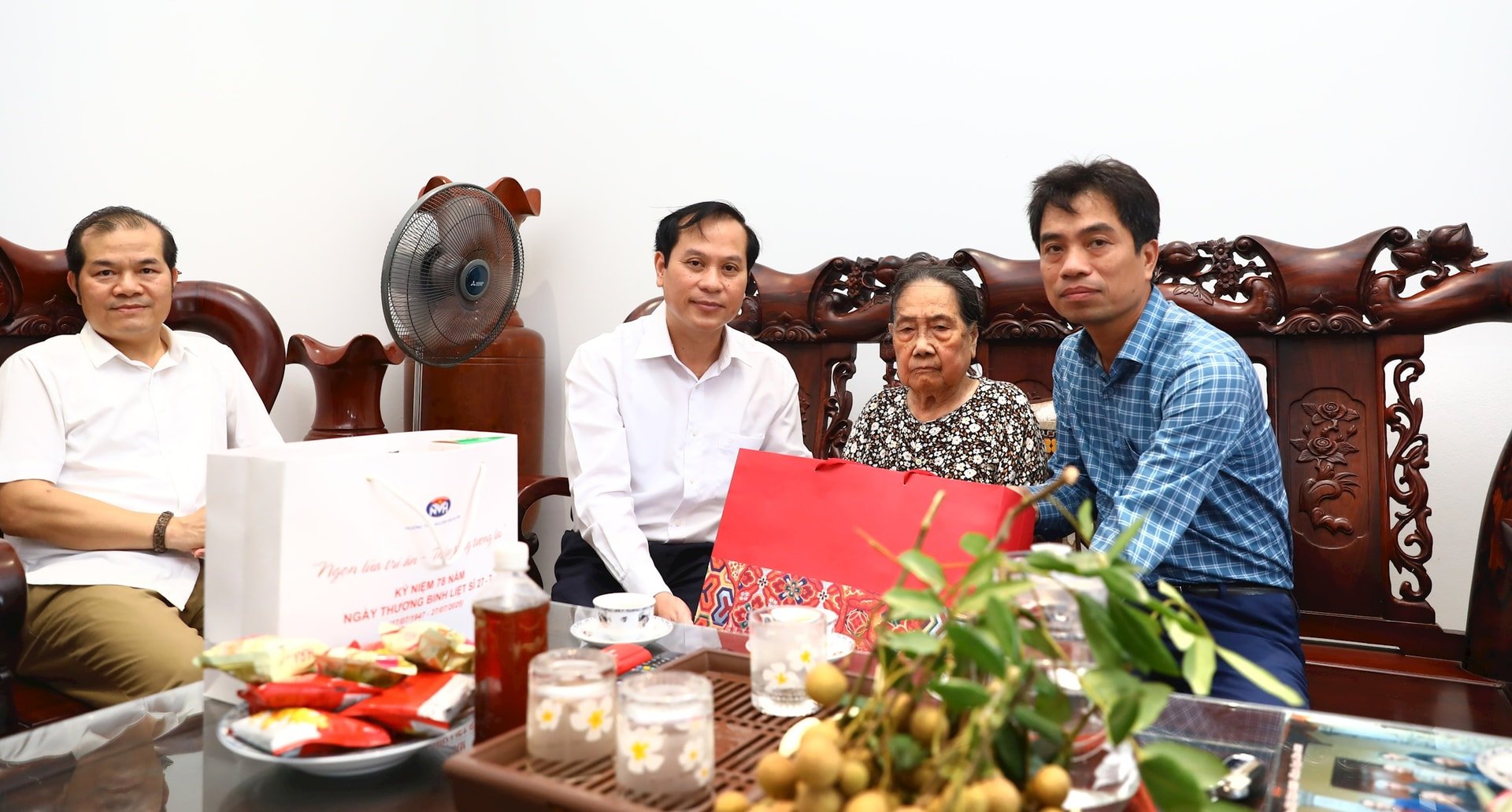Lãnh đạo xã Sơn Đồng trao quà tặng Bà mẹ Việt Nam Anh hùng Nguyễn Thị Trình. Ảnh: Ánh Dương