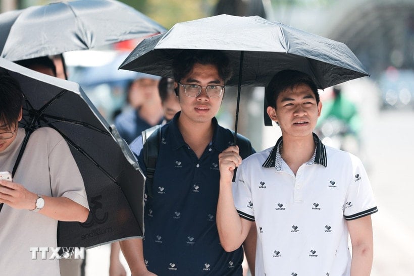 Ô là công cụ hữu hiệu nhất để tránh nắng của người đi bộ. (Ảnh: Lê Đông/TTXVN)